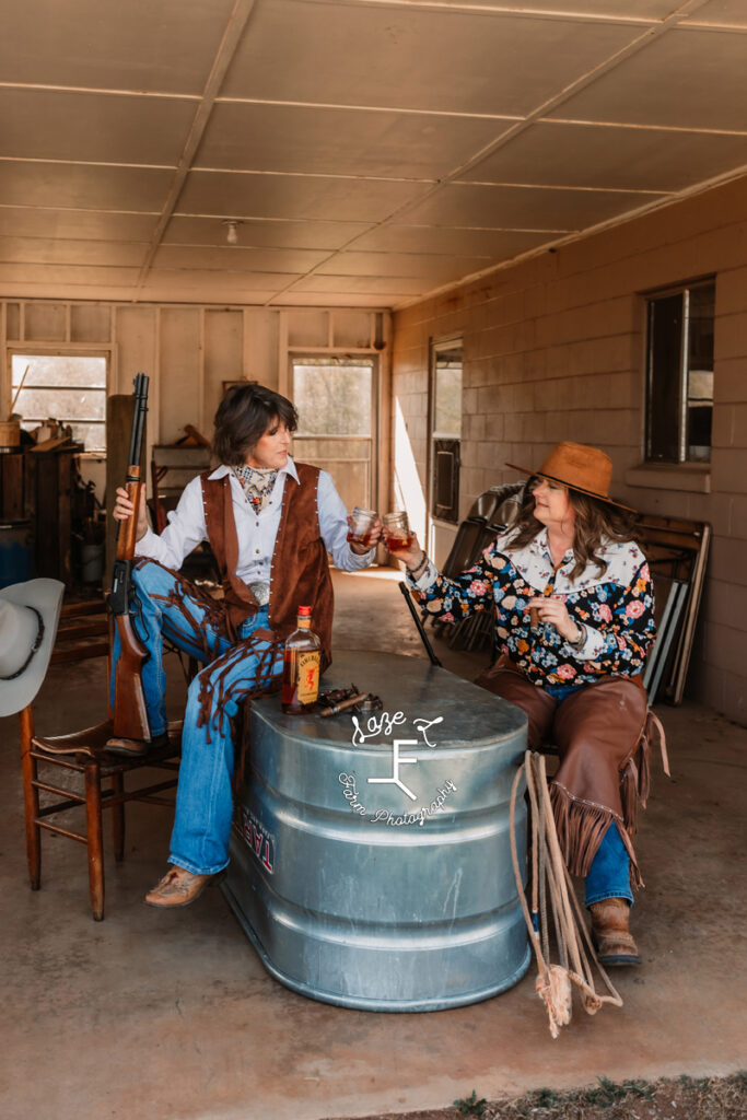 Deb and Deanna sitting with cigars and whiskey