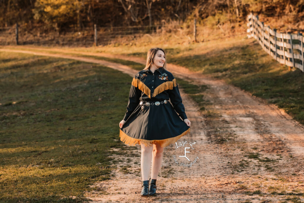 Calista in blue and gold fringe dress walking on dirt road