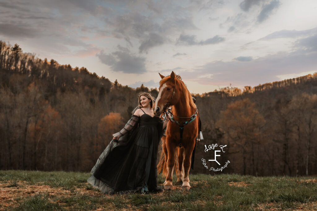 Calista standing with Gus in black dress at sunset