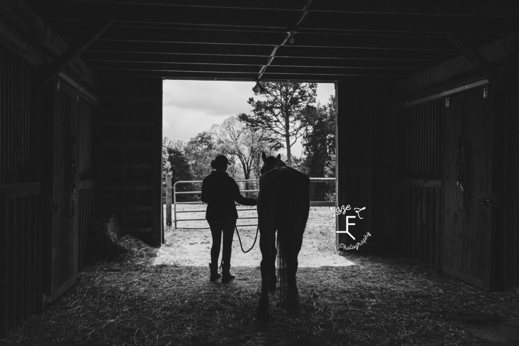 DeAnne and Buddy in the barn in black and white 