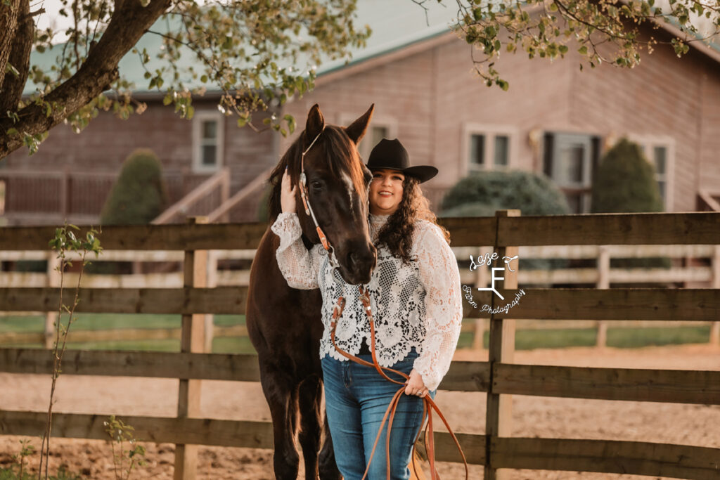 Kody standing with her mare in a white lace shirt