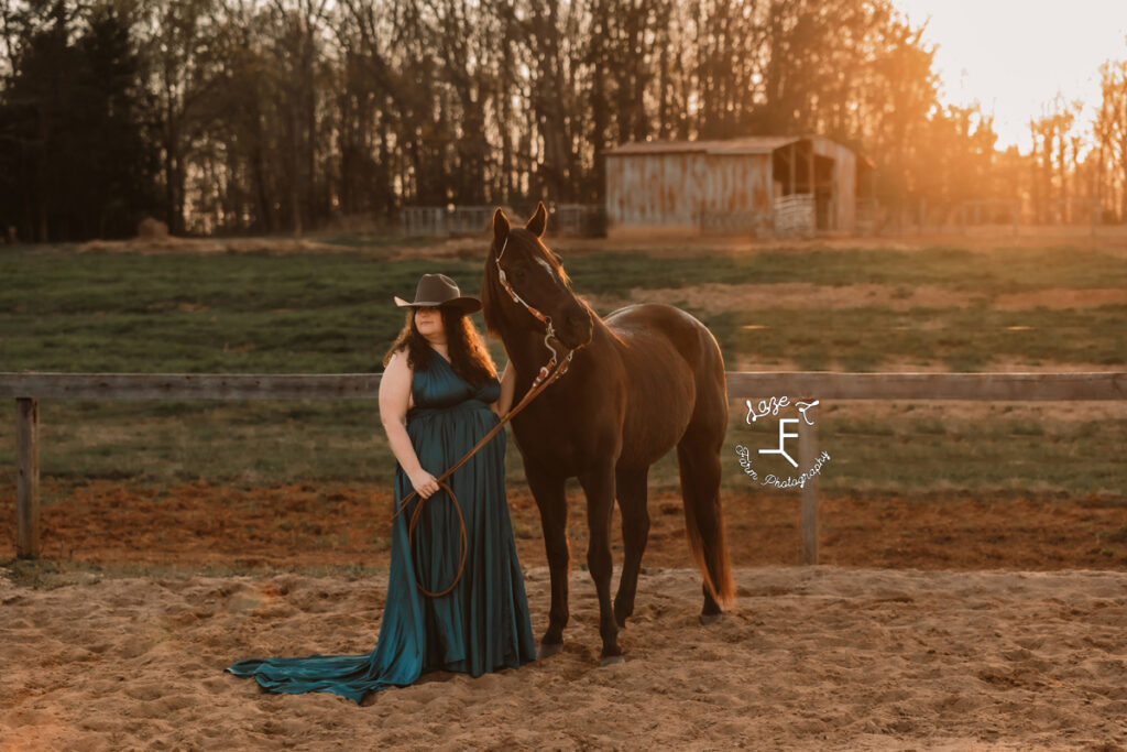 Kody in turquoise dress standing with her mare