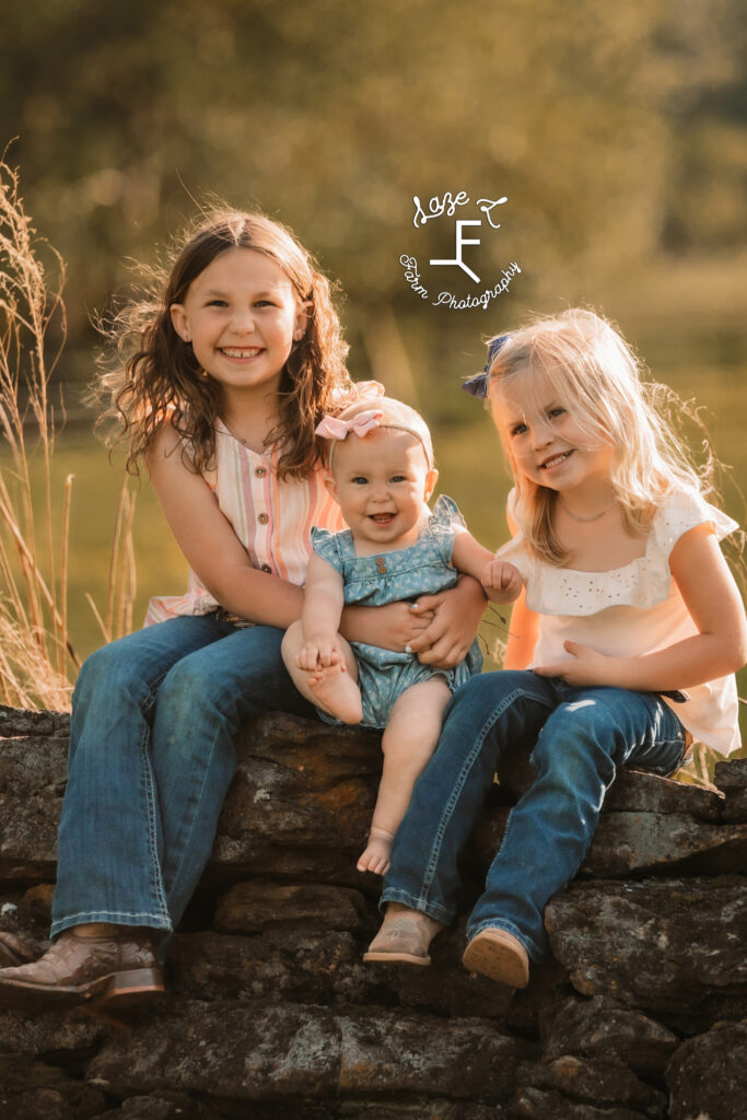 Galliher girls sitting on stone wall