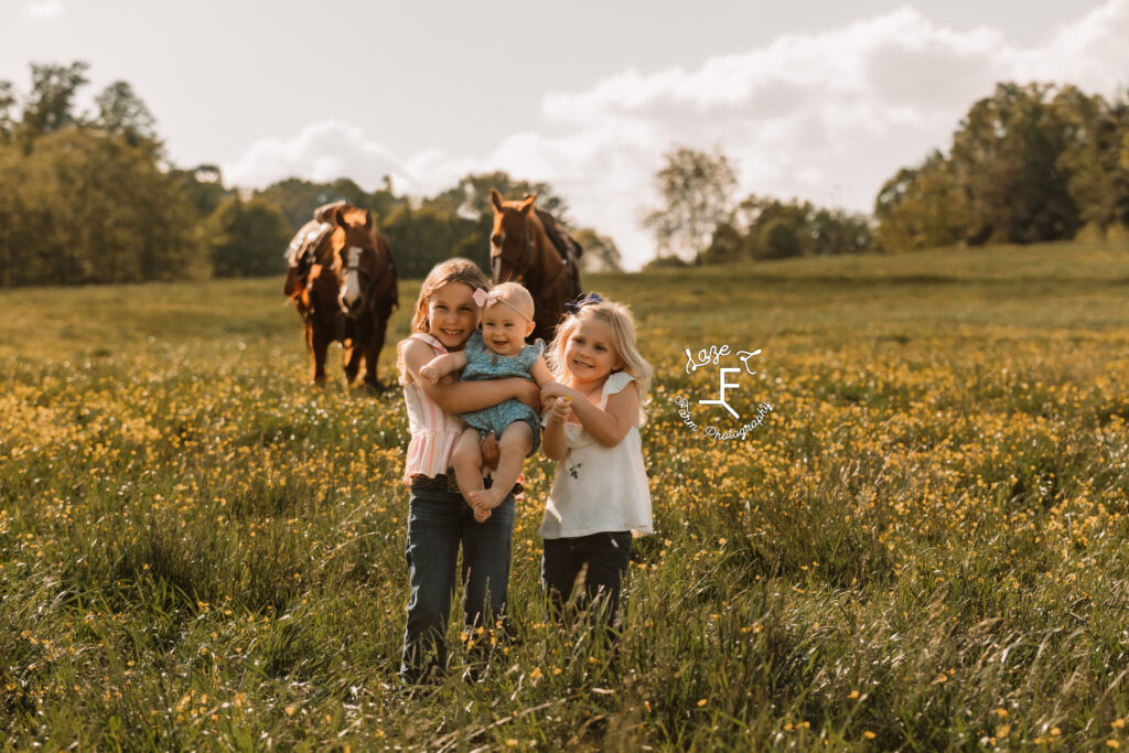 Galliher girls standing together with horses in background