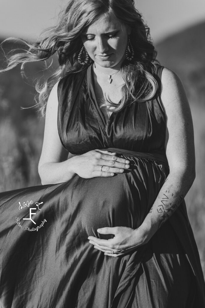 Alex holding baby bump in black and white