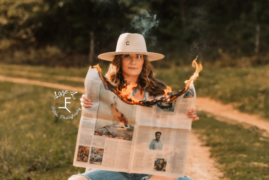 Wendy holding burning newspaper