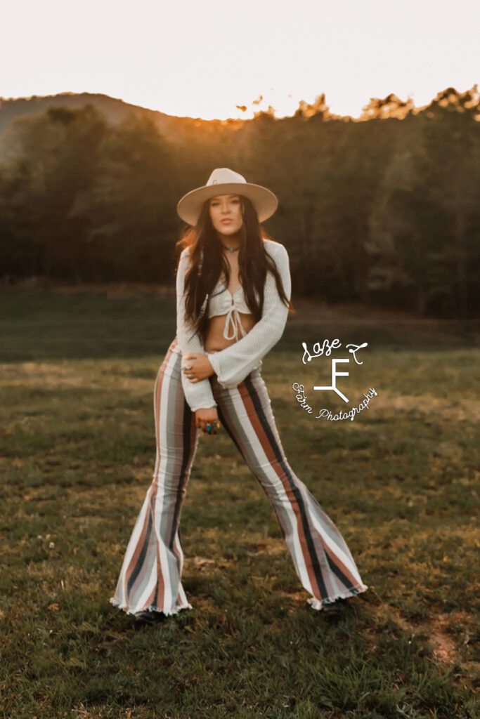 Halle in striped bell bottoms standing in field