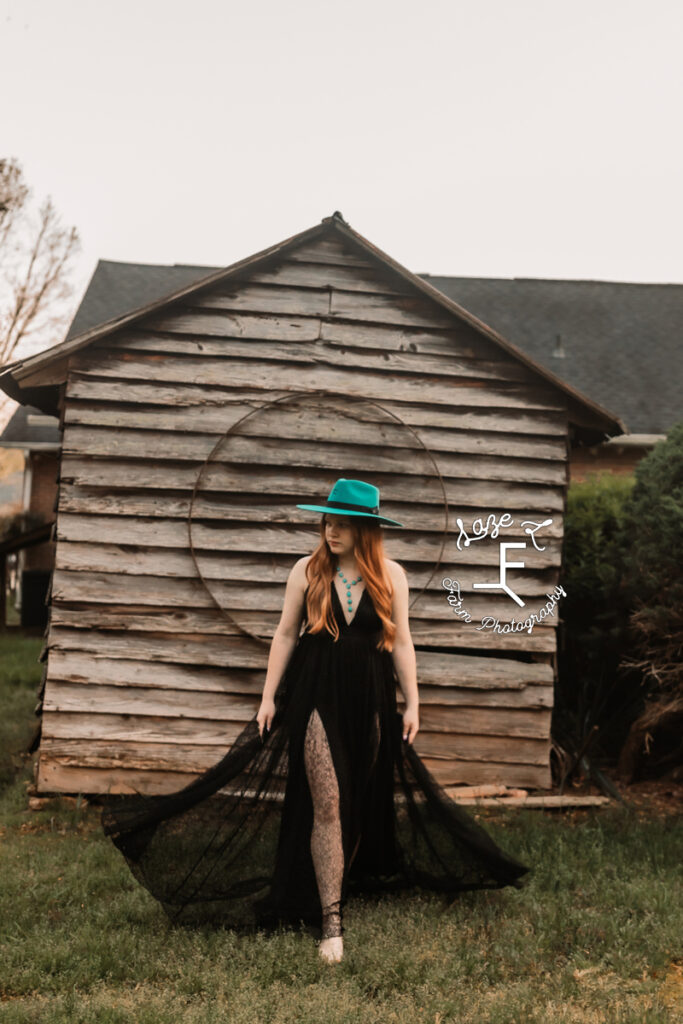 Bailey in turquoise hat and black dress walking