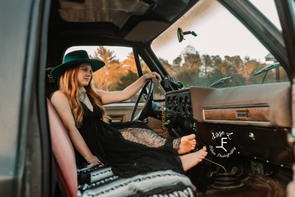 Bailey in turquoise hat and black dress in truck