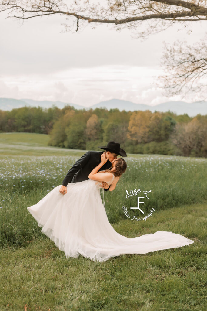 Gabbi and Brad dip kissing in front of field