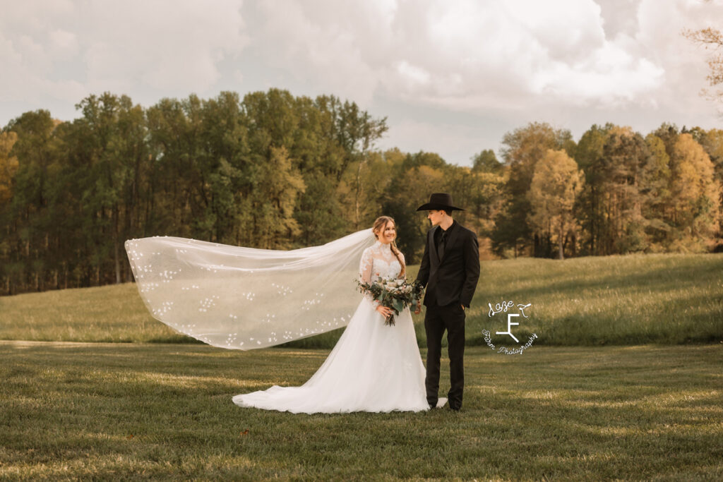 Gabbi and Brad standing together with wind blowing her veil