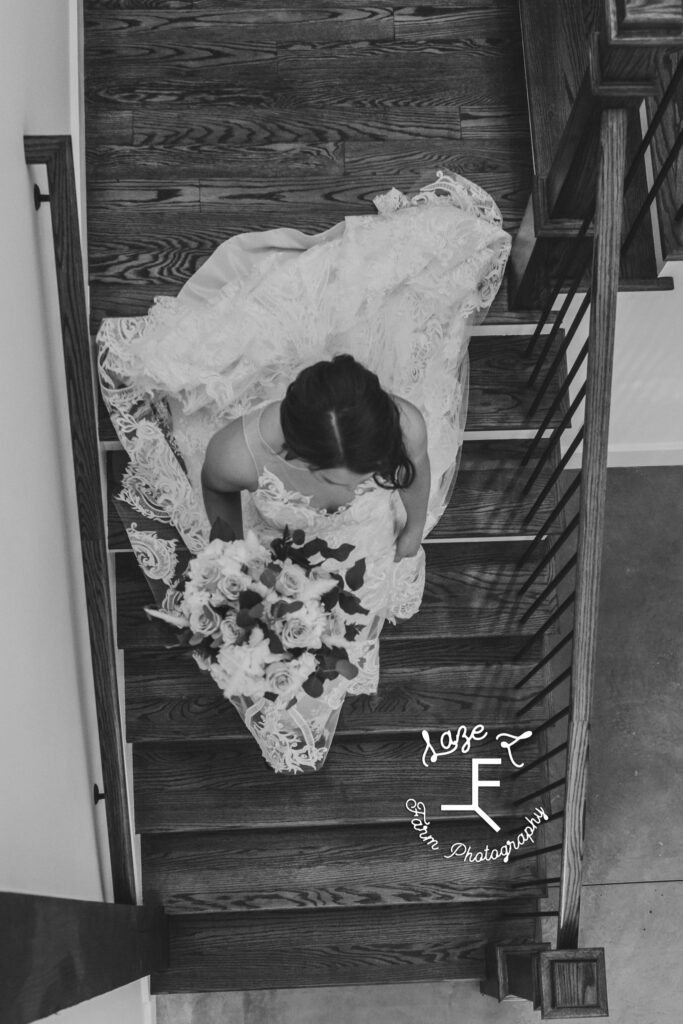 bride walking down stairs from above in black and white