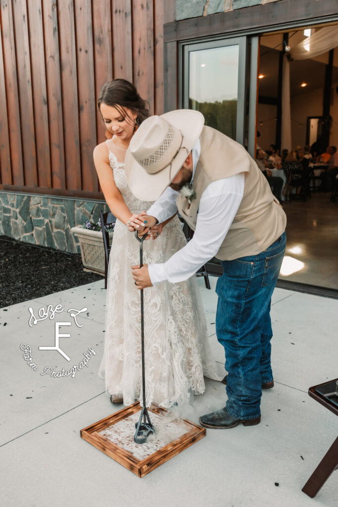 bride and groom branding a framed piece of leather