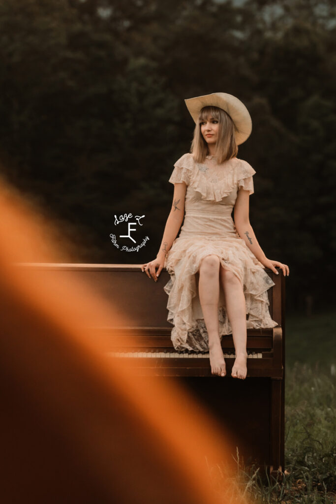 cowgirl sitting on a piano