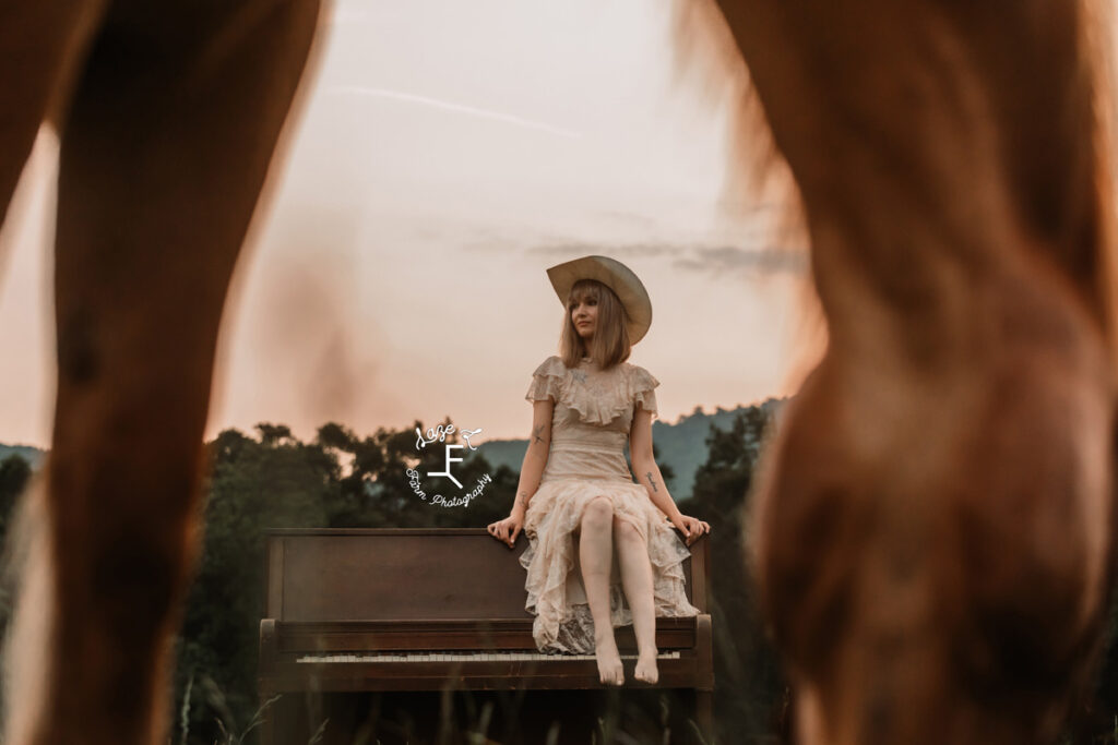 cowgirl sitting on a piano