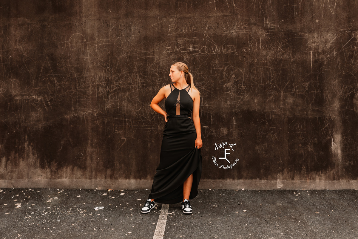 girl standing in front of wall in prom dress