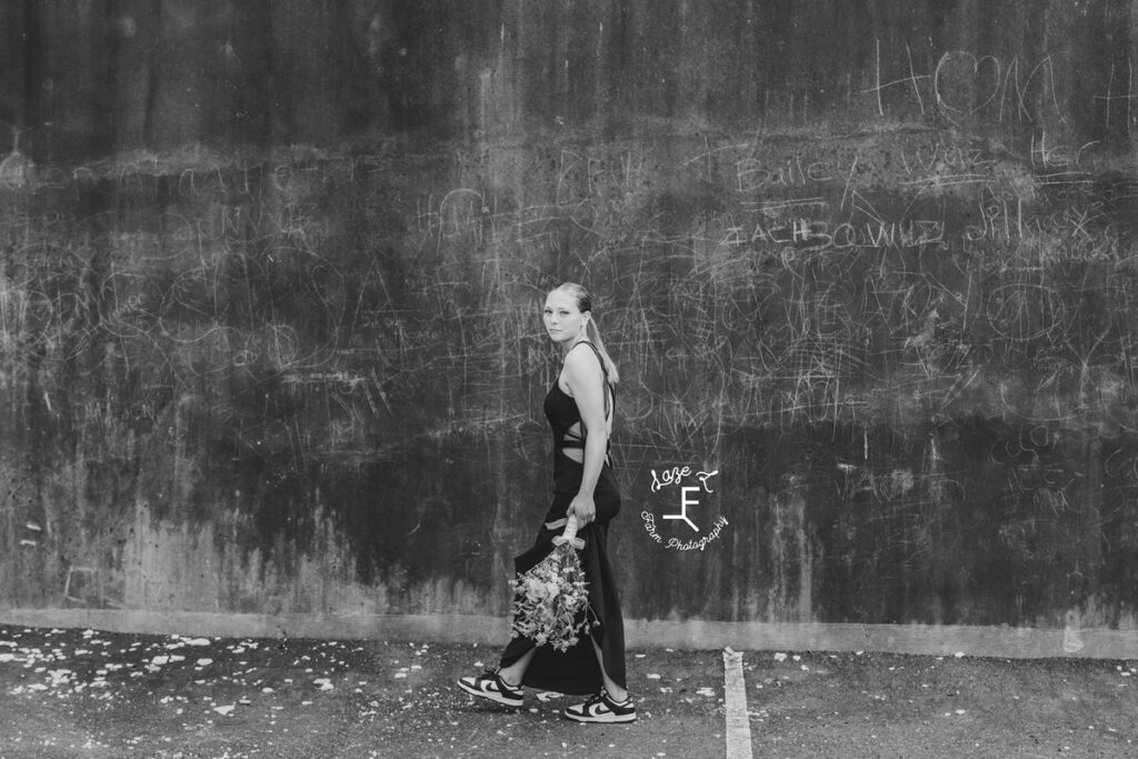 girl walking in front of wall in prom dress