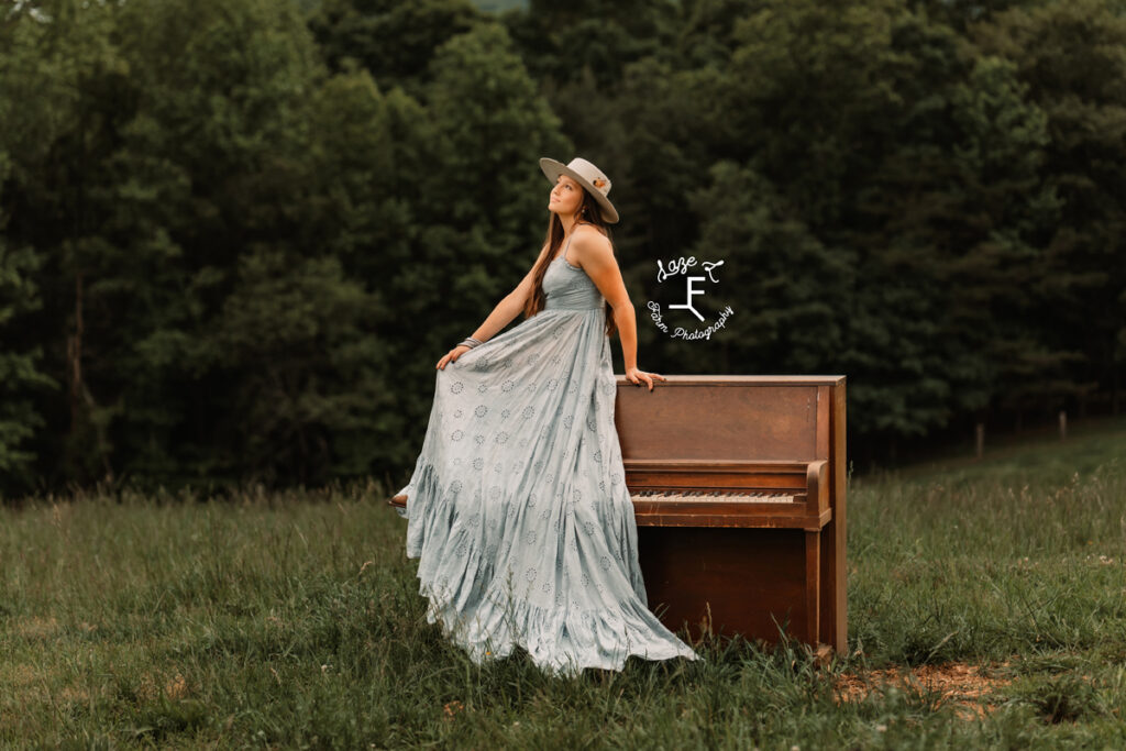 girl sitting on piano in flowy dress