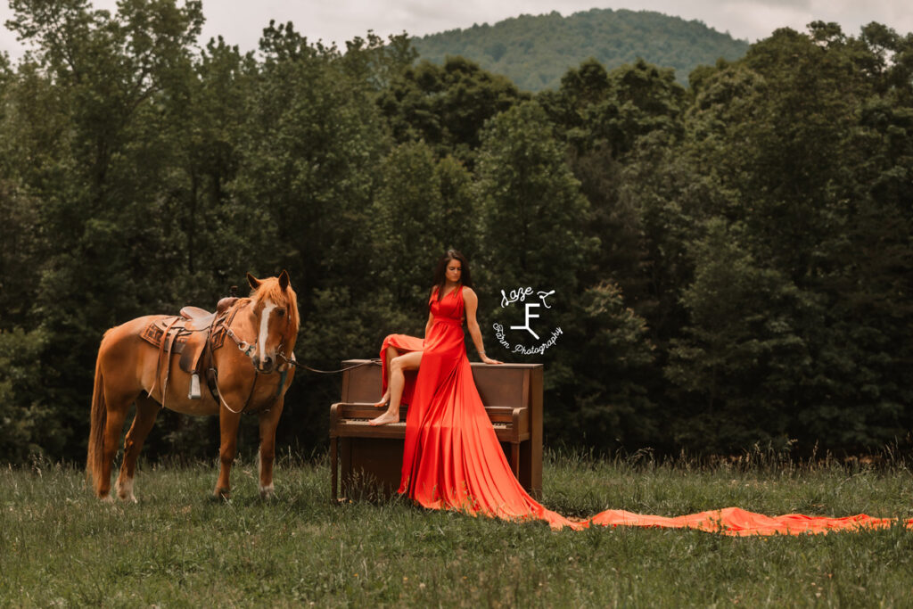 cowgirl with horse sitting on a piano with a red parachute dress