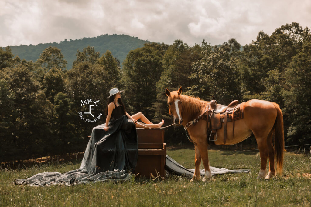 cowgirl with black parachute dress on a piano