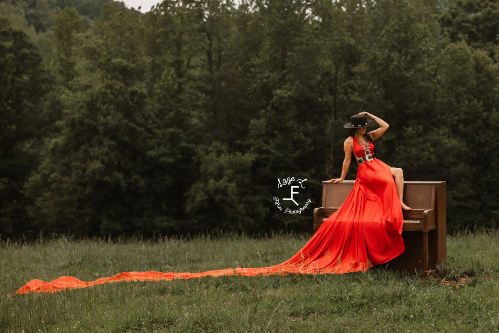 cowgirl with horse sitting on a piano with a red parachute dress