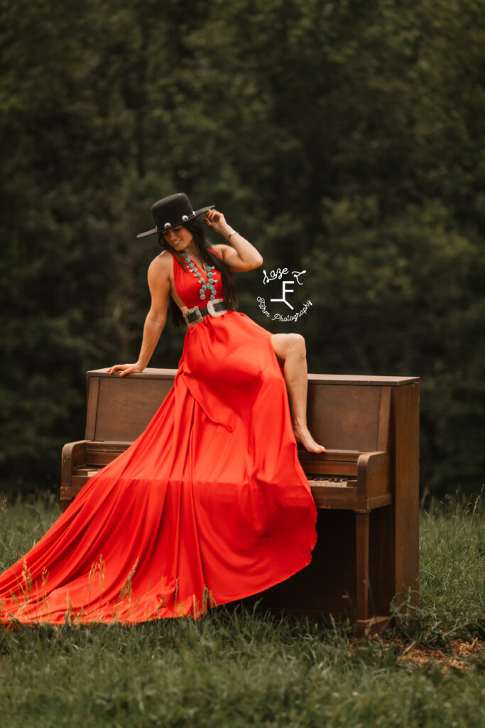 cowgirl with horse sitting on a piano with a red parachute dress