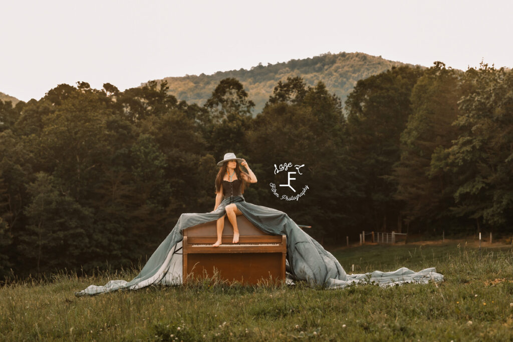 cowgirl with black parachute dress on a piano