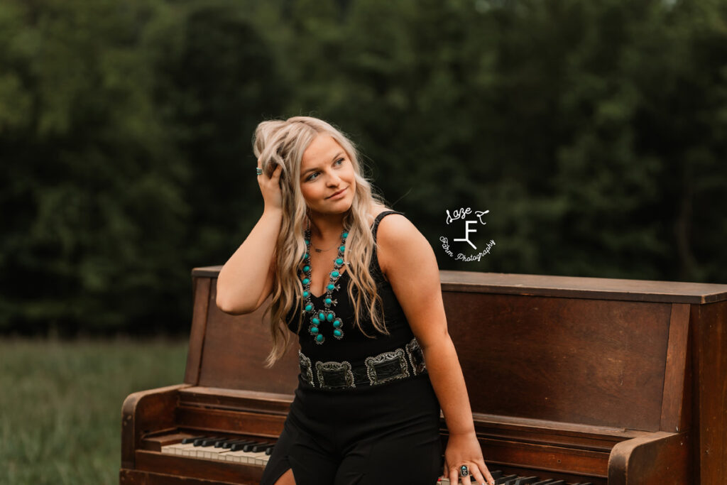 a girl leaned up against a piano