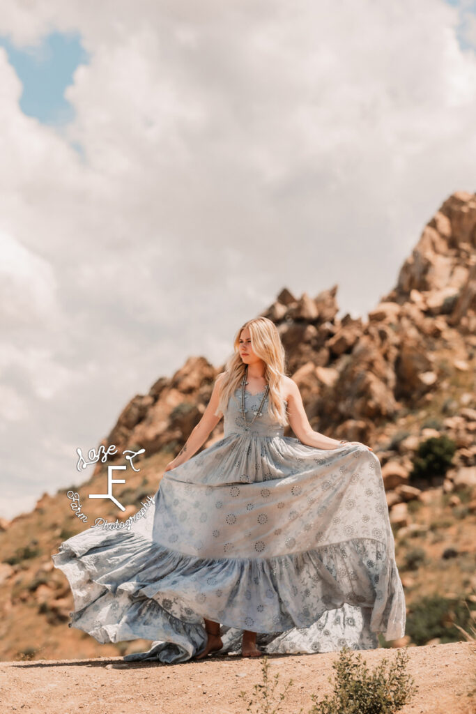 Reid in blue lace dress in front of rock formation