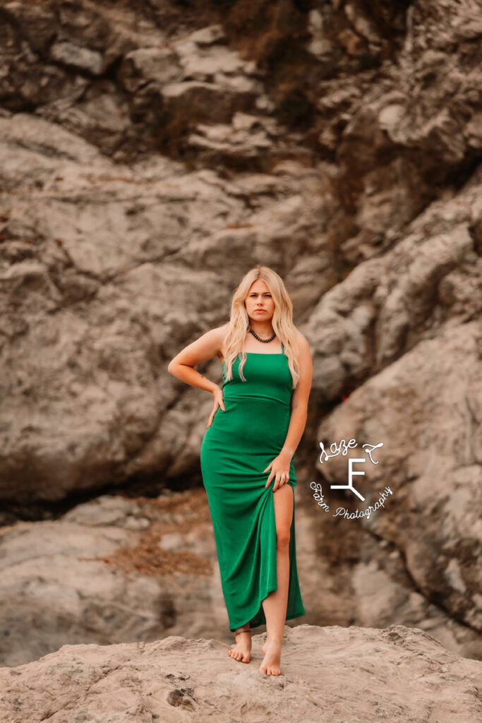 Reid in green dress standing on rocks