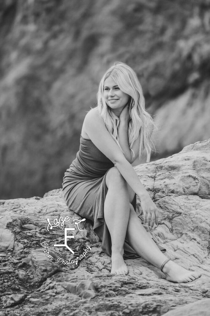 Reid sitting on rocks in black and white