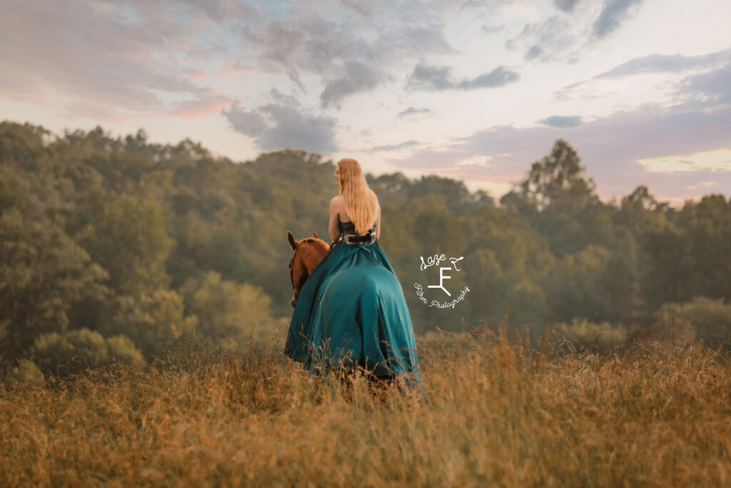 cowgirl on horse in a dress at sunset