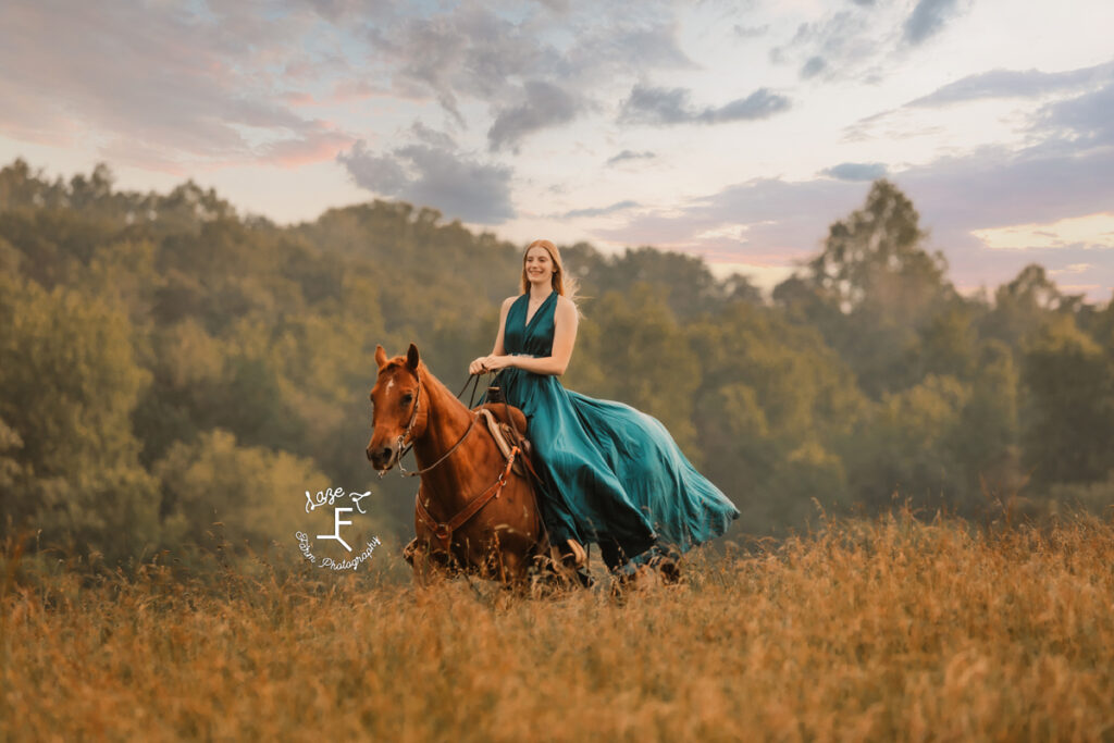 cowgirl on horse in a dress at sunset