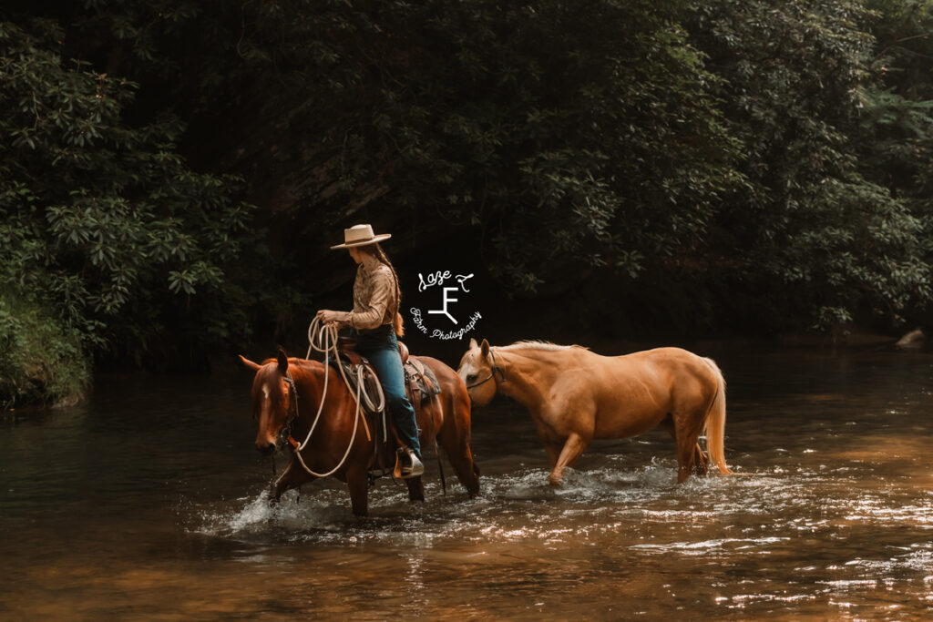 cowgirl riding horse in river