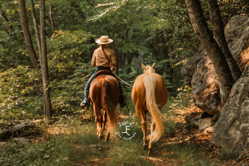 cowgirl riding horse on the trail