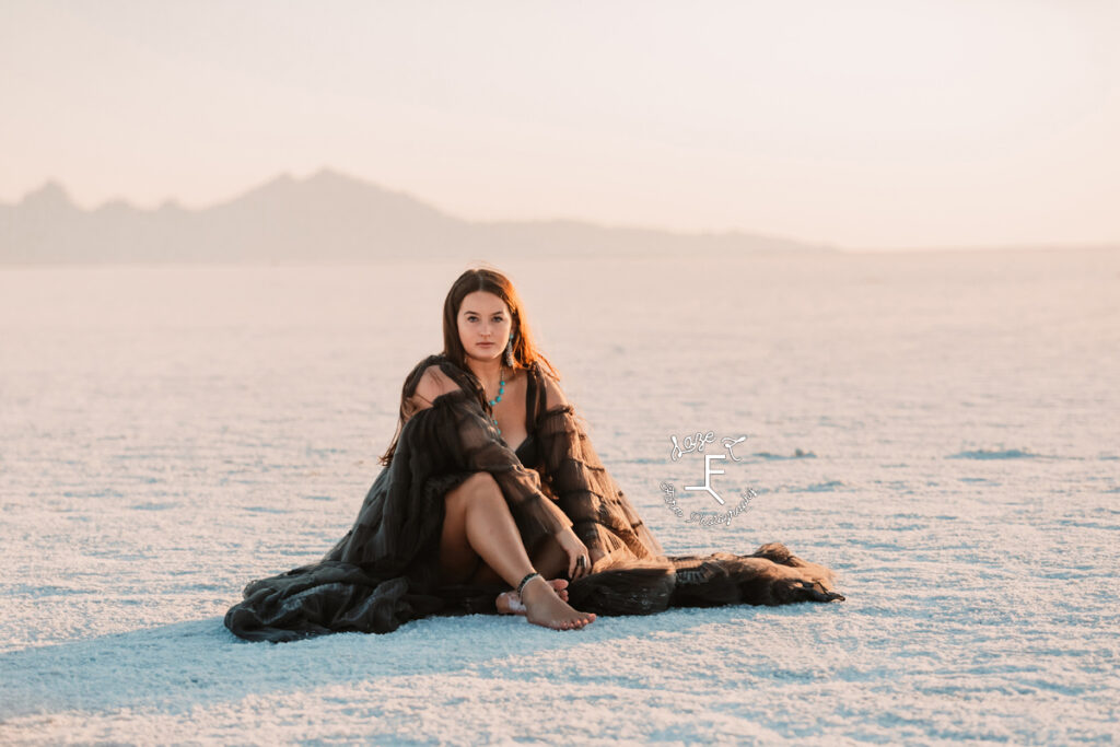 Savannah sitting on salt flat in black dress