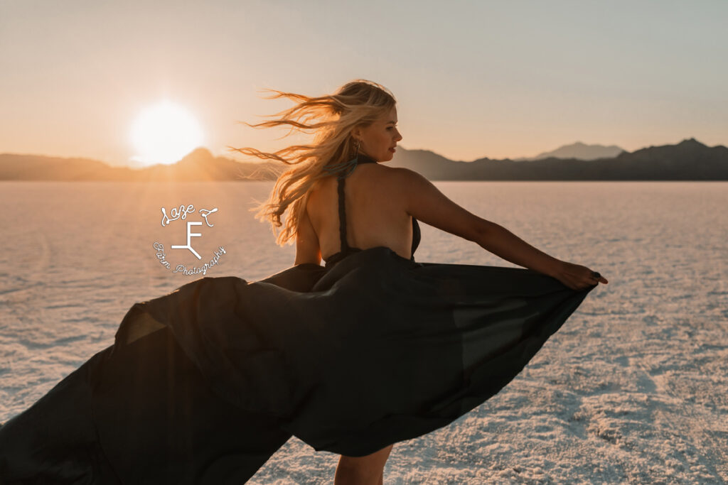 Reid in blue dress walking away with sun over left shoulder