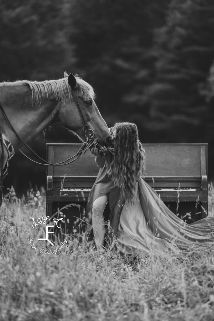 Girl sitting on piano stool kissing Gus in black and white