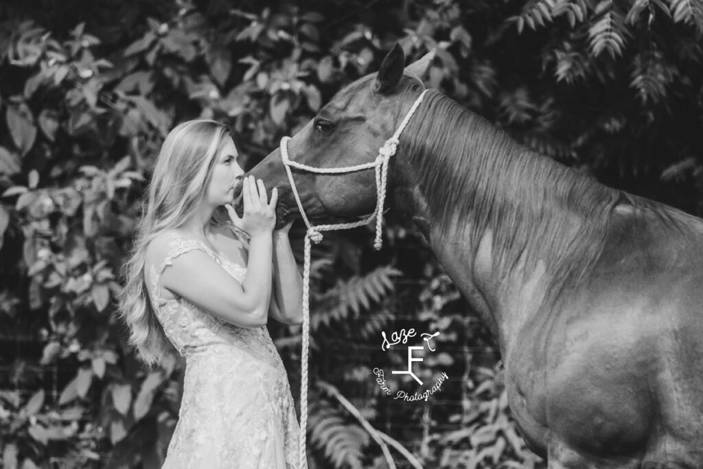 Morgan kissing horses nose in black and white