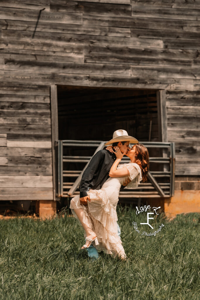 Ambry and Josh kissing in front of barn