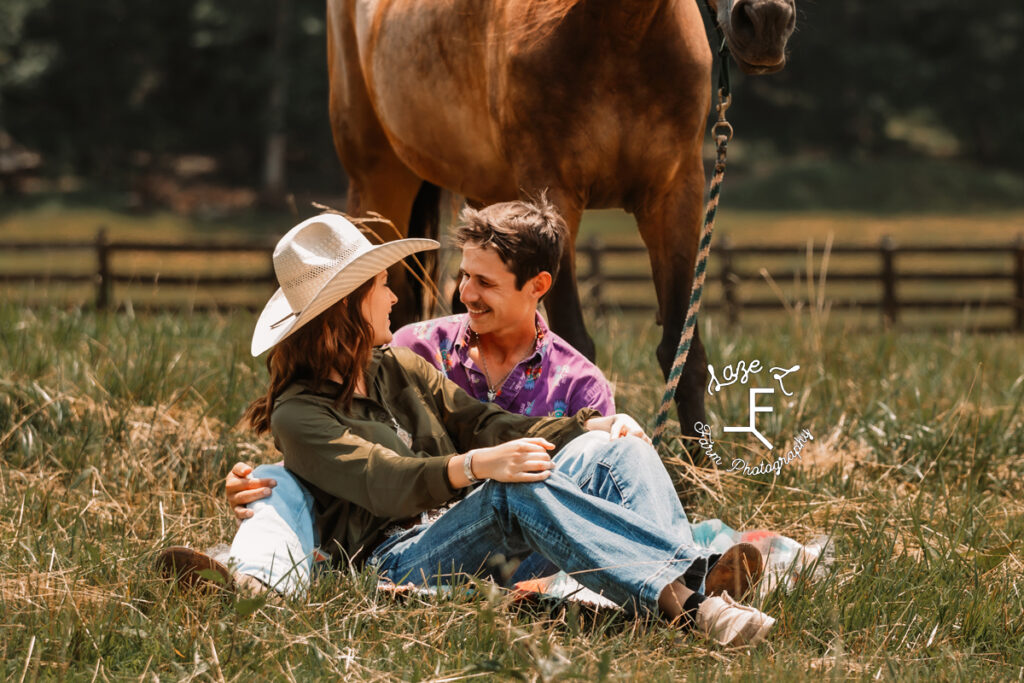 Ambry and John sitting in field with horse behind them