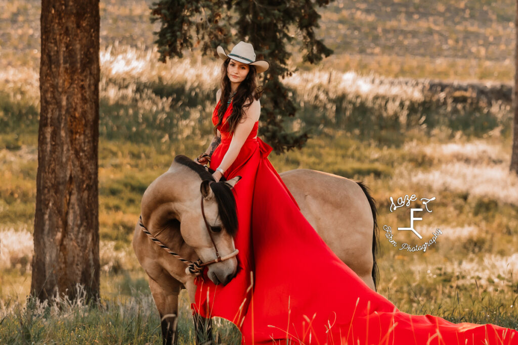 Dakota sitting on buckskin in red parachute dress