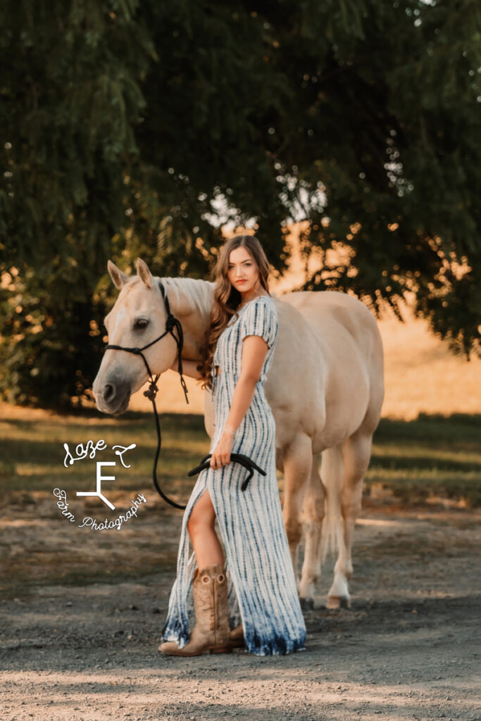 Tevis in blue and white dress with Palomino horse