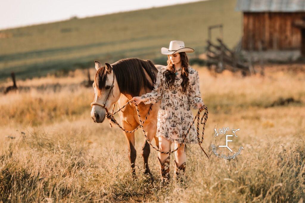 Dakota walking with Buckskin through a field