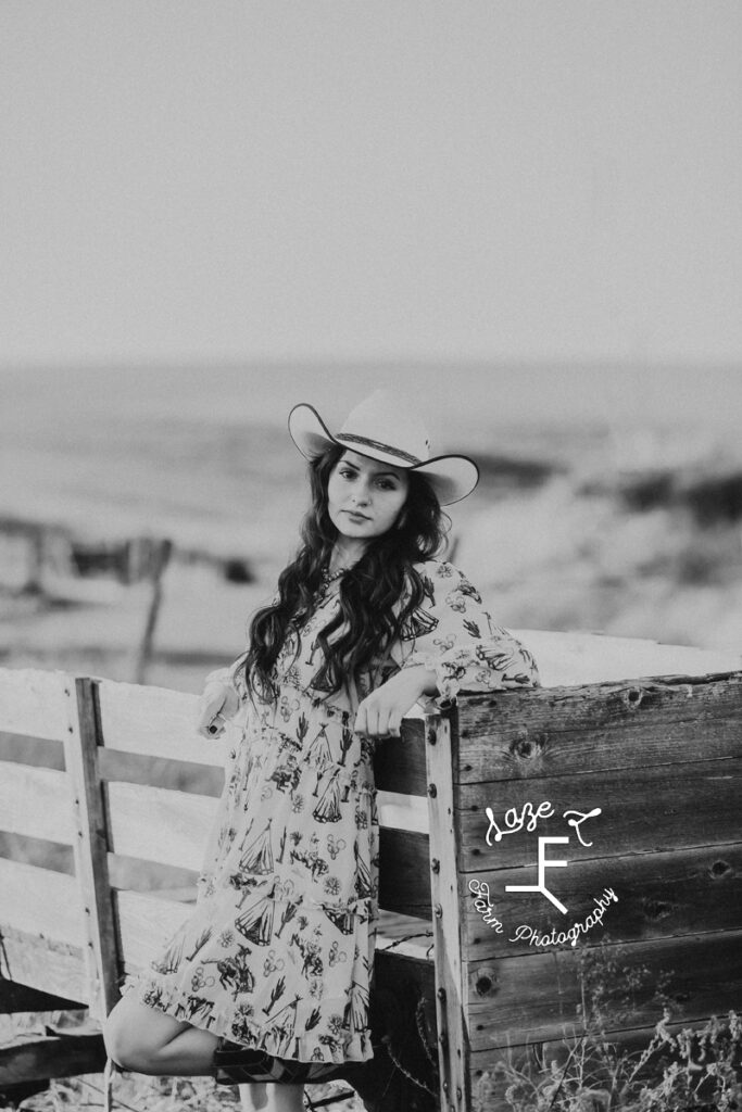 Dakota leaning on fence in black and white