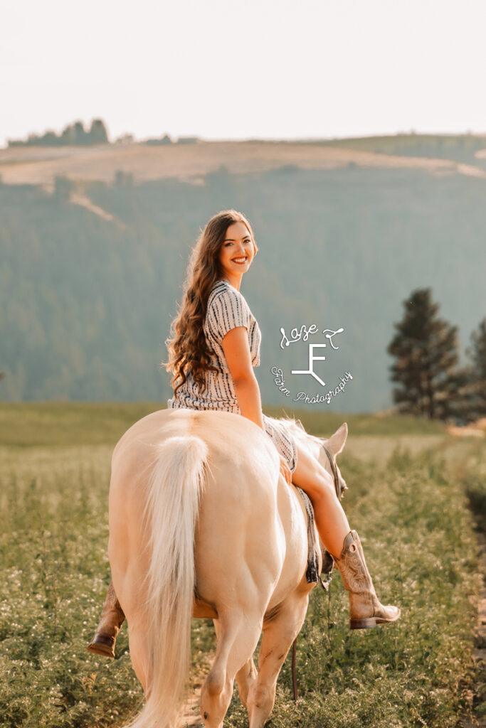 Tevis riding Palomino horse bareback looking at camera over shoulder