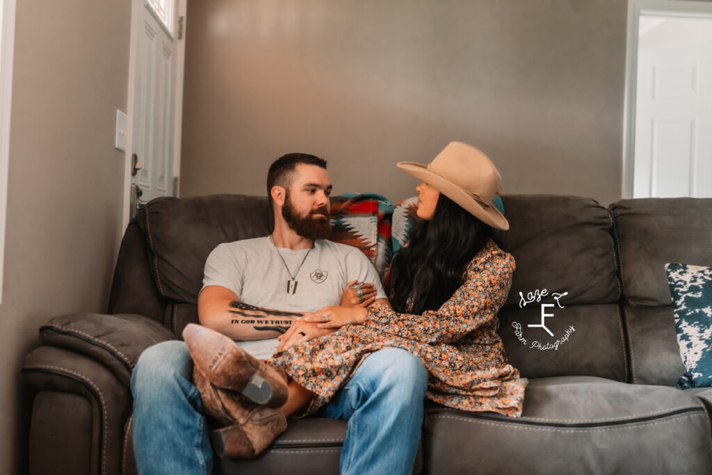 Couple sitting on couch looking at each other 