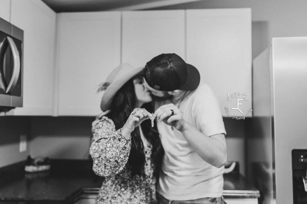 Couple holding key to new house kissing in black and white