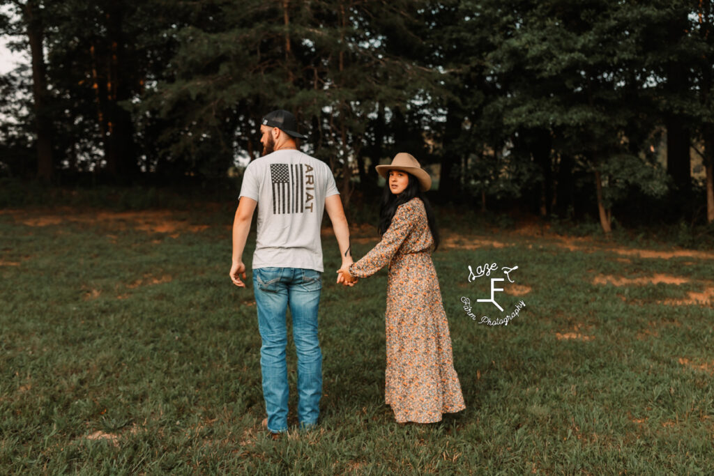 couple walking away from camera with wife looking back