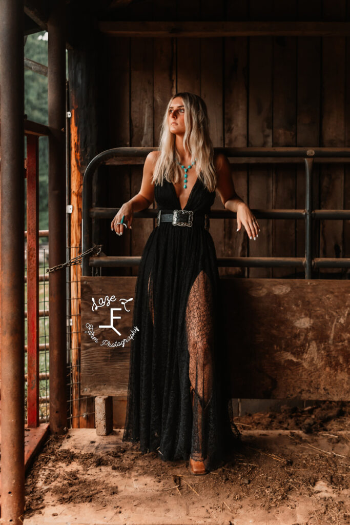 Model leaning against gate in the barn